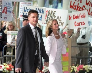 Andrew Wakefield attends the hearing in 2008, flanked by his wife and supporters displaying placards.